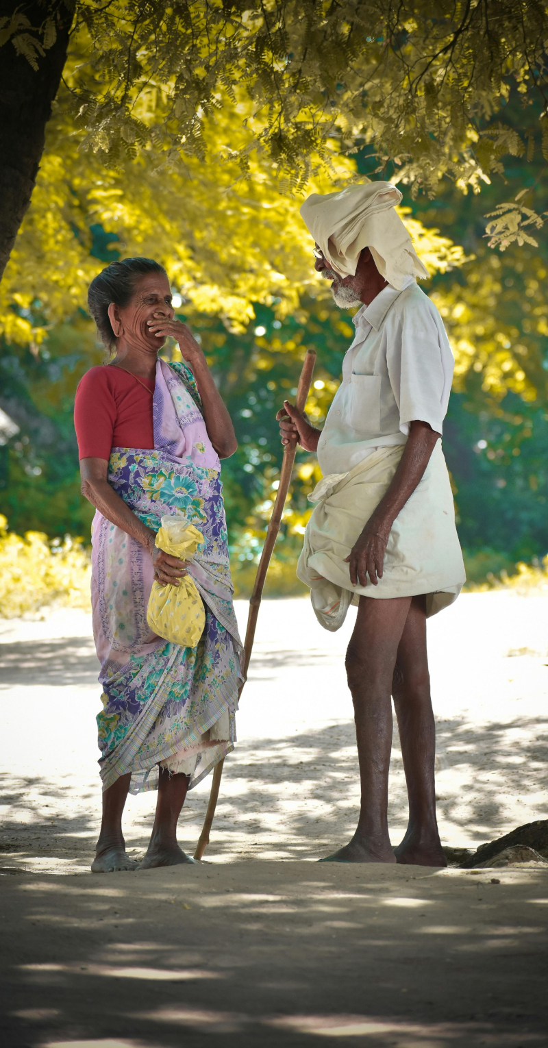 man and woman talking under tree